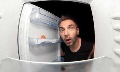 Человек заглядывает в холодильник